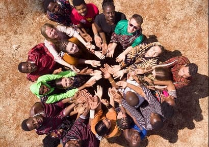 A circle of people joining hands from above