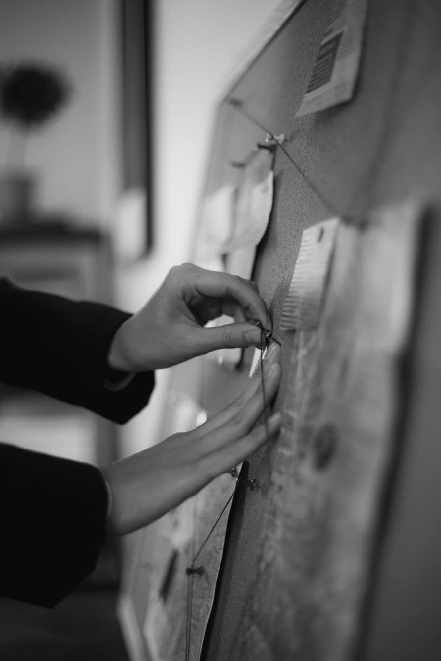 A hand pinning notes to a planning board